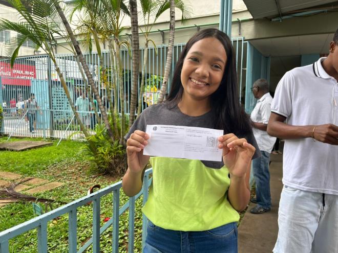 Tainara segurando, toda orgulhosa, o título de eleitor 