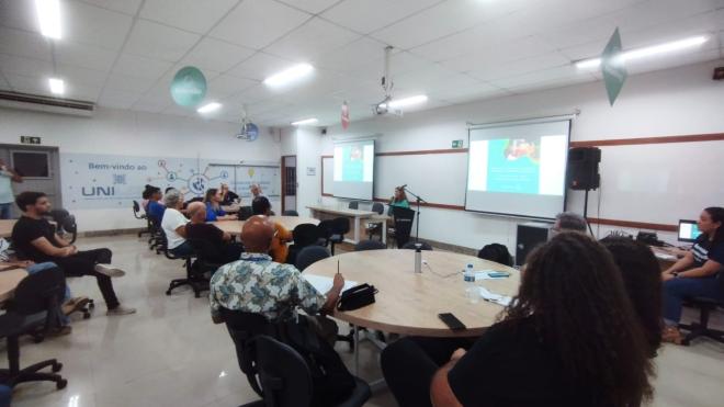 A psicoterapeuta Claudia Moraes relata aos participantes como uma de suas pacientes evoluiu positivamente após o uso da Ayahuasca. Foto: Vinícius Rosa.