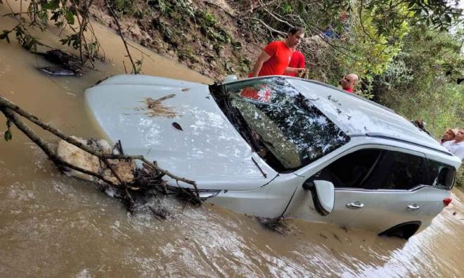 Motorista tentou atravessar um córrego, que estava cheio por causa da chuva intensa, mas veículo foi arrastado, uma mulher e uma criança morreram o motorista e um adolescente sobreviveram 