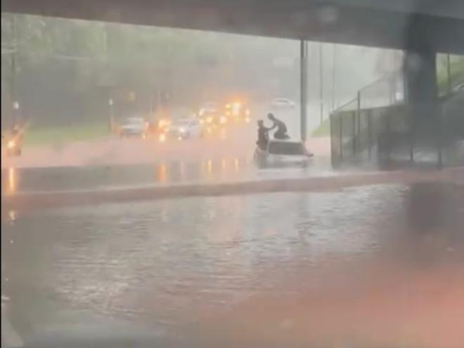 Na avenida Brasil, debaixo do viaduto da BR-381, casal teve que subir no teto de um carro que agarrou na área inundada 