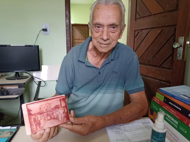 Nascido e criado no Melo Viana, Juarez Bhering mostra uma antiga foto com moradores reunidos