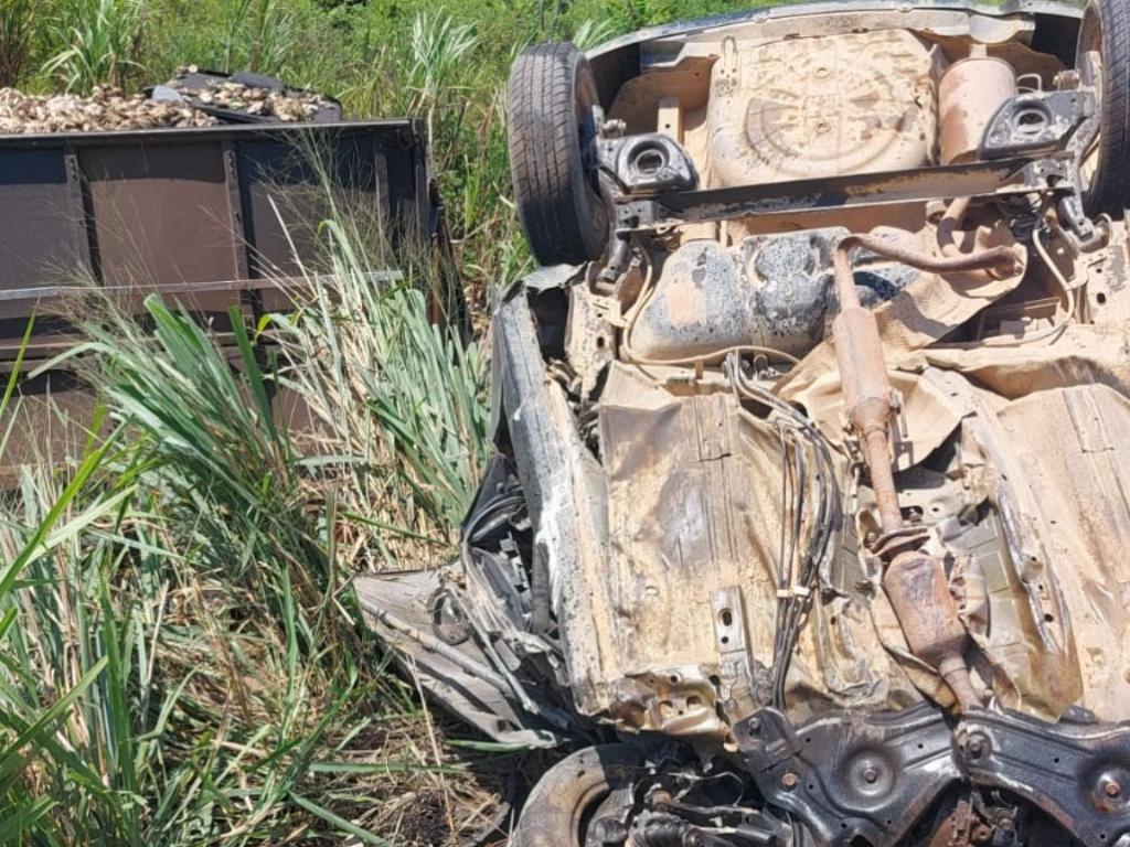 Com o impacto, caminhão e carreta foram parar no meio do mato à margem da rodovia e o Nissan capotou
