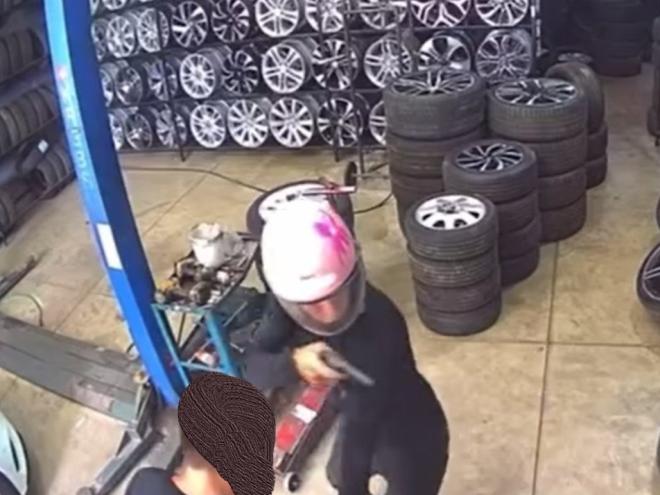 O momento que o assaltante mira a arma para a segunda vítima rendida no estabelecimento