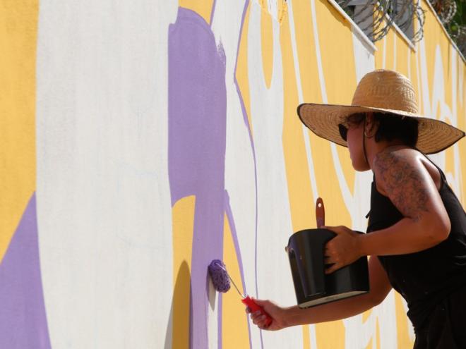 A artista Elisa Bara em ação na produção dos painéis