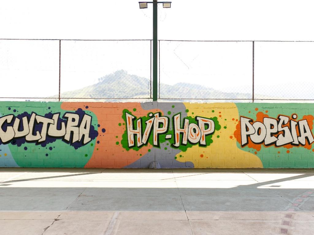 Grafitagem coletiva de um painel na quadra da escola