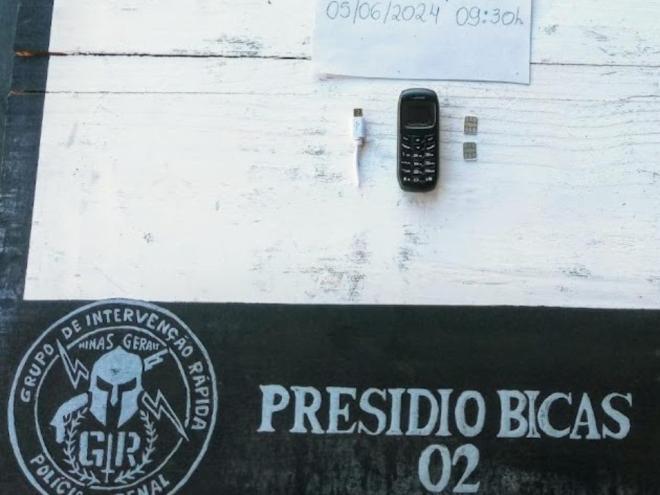Um dos mini celulares apreendidos dentro de um saco de bata-palha enviada a custodiados no presídio de Bicas 