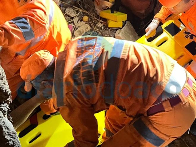 O momento que a vítima é retirada debaixo de uma pedra, após cair de uma ponte em Fabriciano