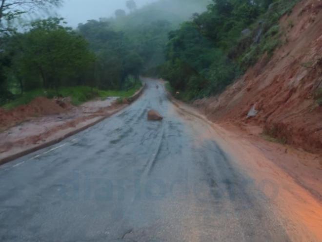 Chuvas e encosta desprotegida fazem com que terra e pedras desloquem para a rodovia, ocasionando riscos a quem transita pelo local