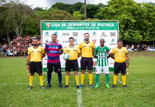 O trio de arbitragem com os dois capitães antes do duelo decisivo
