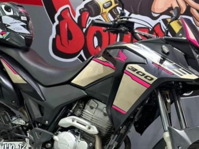 Moto é preta e tem detalhes em rosa e dourado
