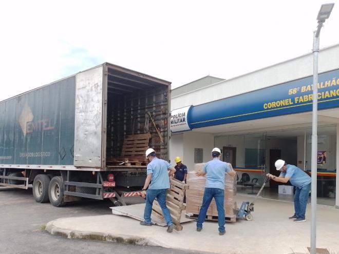 Colaboradores da Copasa entregando uma quantidade dos copos com água no 58º Batalhão da PMMG, em Coronel Fabriciano
