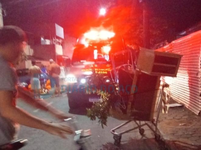 Os bombeiros atendem o idoso que sofreu fraturas no corpo ao ser atingido pelo carrinho depois da colisão da moto