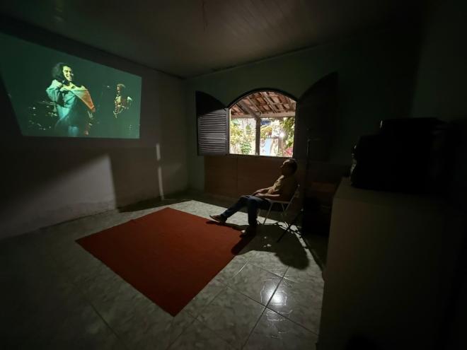 Na sala de cinema, visitantes da casa de cultura se reúnem 