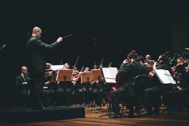 O maestro Vinícius Saturnino rege a Orquestra de Câmara do Vale do Aço
