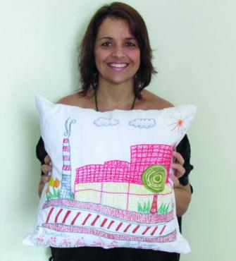 A designer Fernanda La Noce e a almofada que mostra a Usiminas
