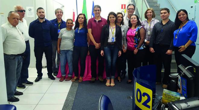 O médico Flávio Dias, em foto com clientes e funcionários do banco