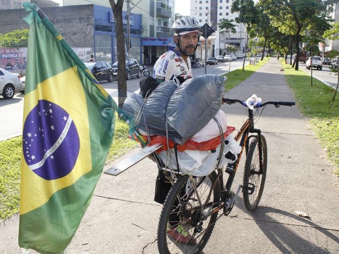 Carregando uma bandeira do Brasil e com penduricalhos na bike, Domingos chama a atenção por onde passada