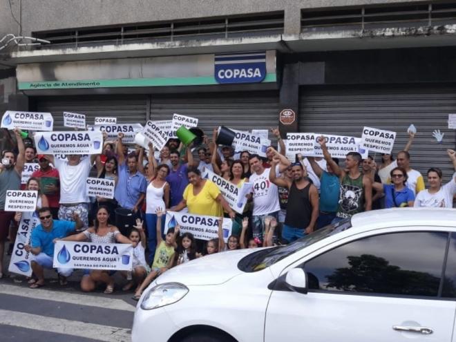 Carregando faixas e cartazes, moradores do Cidade Nova, Santana do Paraíso, fizeram protesto em frente a agencia da Copasa, no bairro Cidade Nobre, em Ipatinga