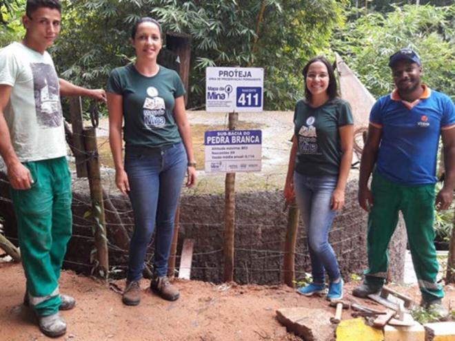 Estagiárias do Unileste fixam as placas de identificação da nascente ao lado dos moradores do Pedra Branca
