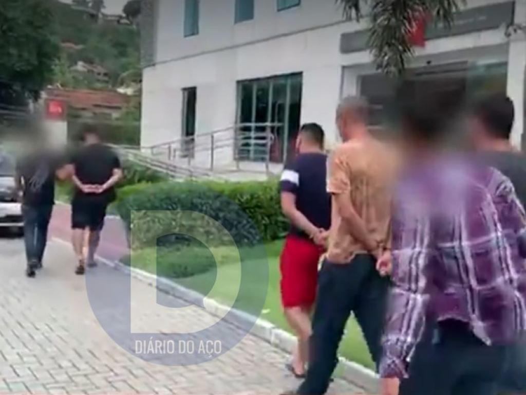 Os policiais conduzindo os suspeitos para a delegacia de Policia