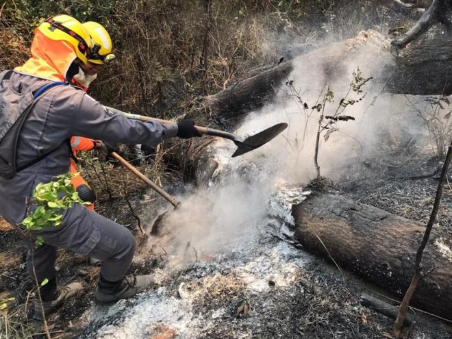 Bombeiros militares têm enfrentado dificuldades no combate ao incêndio, devido ao terreno acidentado 
