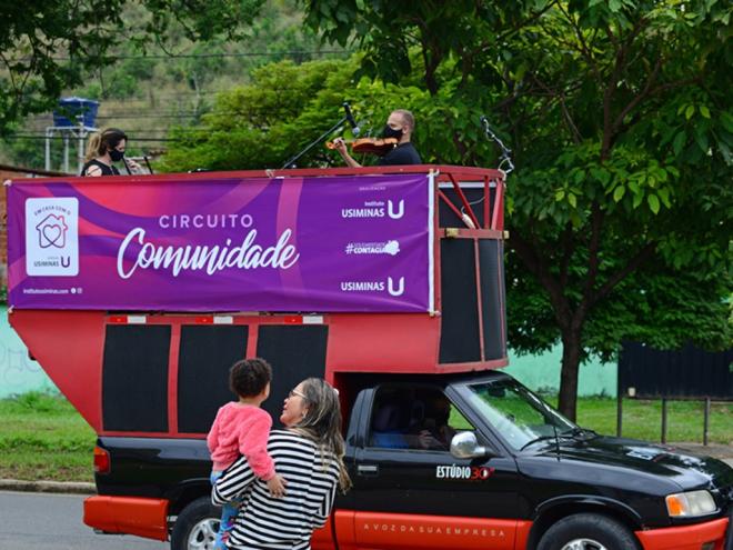 Uma mãe com o filho no colo se encantam com a beleza da música