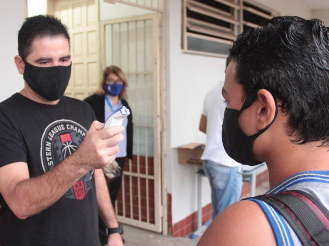 Todos os estudantes tem a temperatura corporal medida por meio de termômetro digital infravermelho