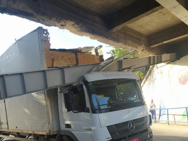 Topo do baú esbarrou na viga, que se soltou de uma das cabeceiras e caiu sobre o caminhão 