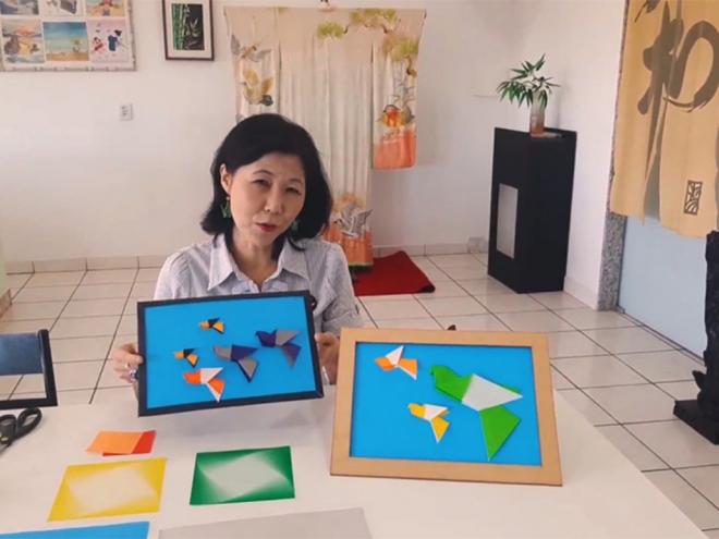 Yoshiko Honda ensina a fazer um quadro composto de passarinhos de origami