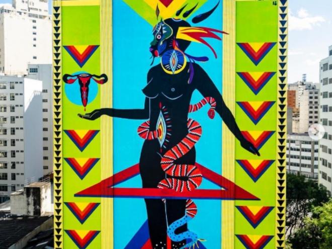 Híbrida astral (Guardia brasileira). A autora, Criola, explica: ''Ancorada na matriz dos povos originários e do povo preto que se interconectam sustentando uma espiritualidade verdadeiramente brasileira, emerge em meio a cidade a materialização das híbridas astrais''