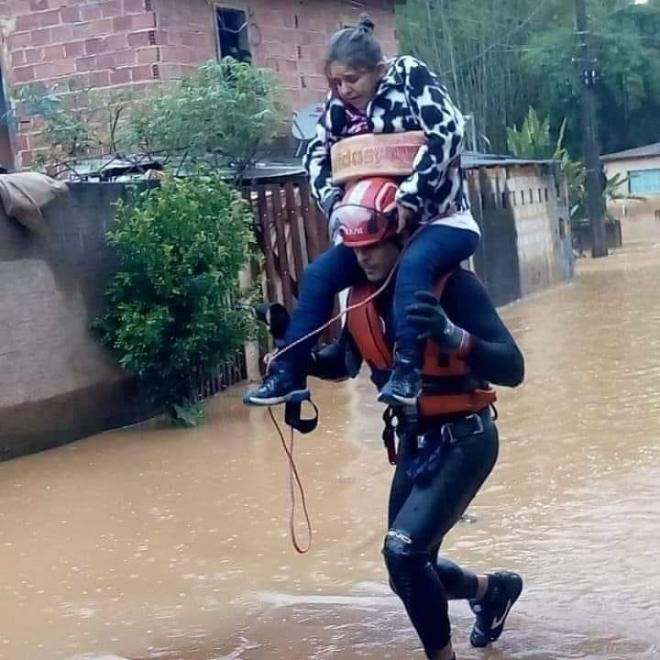 Moradora de área atingida por enchente no povoado de Ponte do Silva, em Manhuaçu, teve dificuldades em sair do local e foi carregada no ombro por um dos bombeiros que atuava no resgate das pessoas