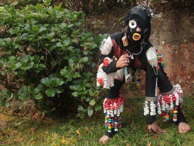 O traje da performance é composto com quase 2.000 tampinhas de garrafas e de frascos, trazendo como reflexão se o lixo produzido aderisse ao nosso corpo e fosse impossível se livrar dele