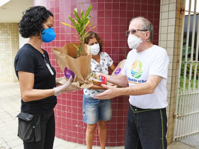 Os moradores participam de ação solidária: mudas de plantas em troca de alimentos