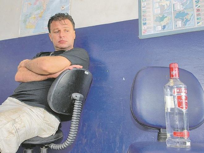 Wagner Dondoni no posto da PRF, olhando a garrafa de vodca encontrada em seu veículo, após acidente com três mortos, em 20 de abril de 2008 (Foto: Marcelo Andrade jornal A Tribuna ES)