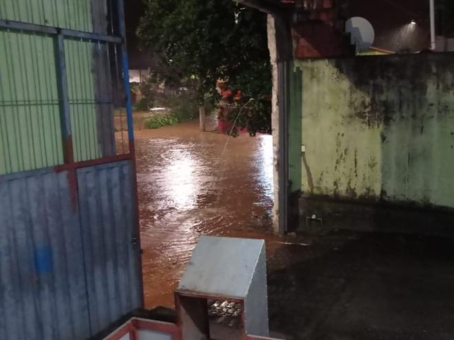 Com a cheia do ribeirão Caladão, água tomou rua e chegou ao portão de garagem 