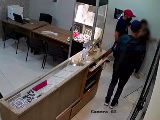 O momento que os bandidos levam a primeira vítima rendida para os fundos da joalheria