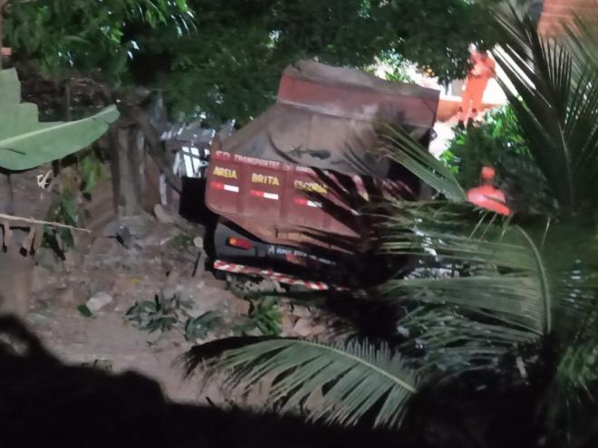 Motorista perdeu o controle do caminhão, que ficou sem freios e caiu em quintal depois de descer barranco de cinco metros 