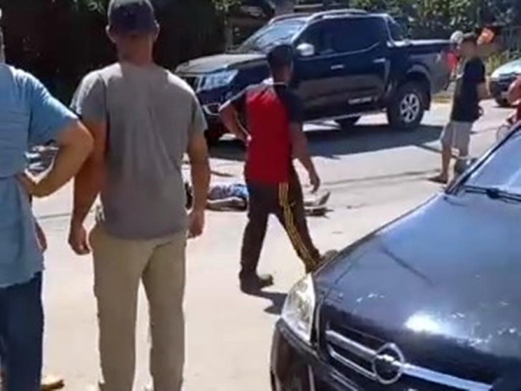 Populares em volta do homem ferido enquanto é aguardado o socorro