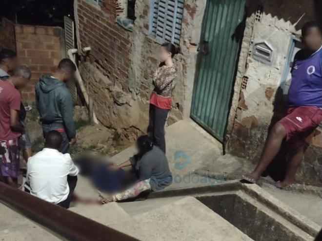 A mãe da vítima ampara o corpo do filho, enquanto aguarda a chegada da polícia